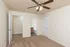 Carpeted bedroom at Embassy Ozark Apartments in Ozark, MO, featuring a ceiling fan with lights, walk-in closet, ensuite bathroom, and neutral walls with white trim and doors.