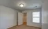 Bright bedroom with large window, neutral carpet, and walk-in closet at Embassy Ozark Apartments.