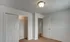 Bedroom featuring a walk-in closet and second entry to the hallway, with neutral paint and carpeting.