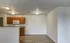 Open kitchen and dining space with hardwood-style flooring and upper oak cabinets at Embassy Ozark.