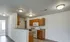 Full kitchen with white appliances, wood cabinetry, and open layout connected to the main living area.