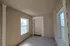 Enclosed hallway at Cobblestone Village showing an elevator with signage and natural light from two large windows, providing accessibility for senior residents.