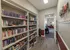 Community library inside Cobblestone Village, showcasing floor-to-ceiling bookshelves filled with books, adjacent to a cozy common area, perfect for residents of this 55+ community.