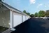 Detached garages and freshly paved parking lot at Cobblestone Village in Springfield, MO, providing convenient covered parking for senior apartment residents.