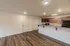 Bright kitchen at Republic Palms Apartments in Republic, MO, with a long breakfast bar, wood cabinetry, black appliances, and easy access to the entryway and storage closets.