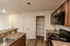 Close-up of the Republic Palms Apartments kitchen in Republic, MO, with black appliances, wood cabinetry, and an open pantry with multiple wire shelves for storage.