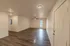Long living room at Republic Palms Apartments in Republic, MO, with wood-style flooring, neutral walls, and a door leading to a private balcony or patio.