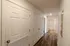 Hallway at Republic Palms Apartments in Republic, MO, featuring multiple storage closets, wood-style flooring, and bathroom access.