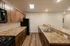 Modern kitchen at Republic Palms Apartments in Republic, MO, featuring wood cabinetry, speckled countertops, black appliances, double stainless-steel sink, and wood-style flooring in an open layout.