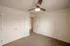 Bedroom with double closet doors &ndash; Cozy bedroom at Republic Palms Apartments in Republic, MO, with plush carpet, a ceiling fan with light, and a double-door closet for ample storage.