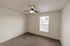 Bedroom with window light &ndash; Bright bedroom at Republic Palms Apartments in Republic, MO, showcasing plush carpet, neutral walls, a ceiling fan, and a large window with blinds for natural sunlight.