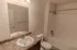 Full bathroom with tub and shower &ndash; Bathroom at Republic Palms Apartments in Republic, MO, featuring a white vanity with speckled countertop, large wall mirror, and a combination bathtub and shower with chrome fixtures.