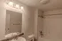 Full bathroom vanity and lighting &ndash; Bathroom at Republic Palms Apartments in Republic, MO, showcasing a speckled countertop vanity, wall mirror, and overhead lighting with three fixtures above a combination bathtub and shower.