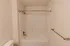 Bathtub and shower combination &ndash; Clean and modern bathroom at Republic Palms Apartments in Republic, MO, with a white bathtub and shower, chrome fixtures, and curved shower rod.