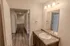 Bathroom vanity with large mirror &ndash; Full bathroom at Republic Palms Apartments in Republic, MO, featuring a white vanity with speckled countertop, chrome faucet, large wall mirror, and overhead lighting.