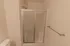Walk-in shower close-up &ndash; Bathroom at Republic Palms Apartments in Republic, MO, highlighting the stand-up shower with glass sliding doors, chrome fixtures, and bright overhead lighting.