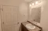 Bathroom vanity with large mirror &ndash; Full bathroom at Republic Palms Apartments in Republic, MO, featuring a white vanity with speckled countertop, chrome faucet, large wall mirror, and overhead lighting.