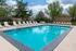 Inviting outdoor pool surrounded by lush greenery and comfortable lounge chairs, ideal for relaxation.