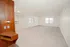 Bright and spacious living room with fresh carpeting, large windows, and warm wooden accents.