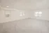 Large living room with light carpet, multiple windows, a window air conditioner, and an entry door.