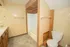 Bathroom at East Manor Apartments with a wood vanity, bathtub and shower, toilet, tiled walls, and neutral flooring.