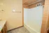 Bathroom at East Manor Apartments with a bathtub and shower surround, tiled walls, neutral flooring, and towel bars.