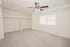 Spacious bedroom with light carpet, a ceiling fan, large window, recessed lighting, and open closet space.