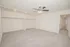 Alternate bedroom view featuring a ceiling fan, light carpet, open closet storage, and access to the hallway.