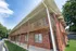 Side view of East Manor Apartments featuring two story wooden balcony walkways and a red brick exterior.
