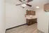 Apartment kitchen with wood cabinets, white appliances, double basin sink, and wood style flooring.
