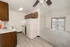 Open kitchen and living room at El Madrid Apartments with white appliances, wood cabinetry, and balcony access.