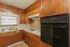 Charming kitchen with classic wooden cabinets, sleek appliances, and a large window providing ample natural light.