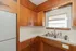 Charming kitchen with vintage wooden cabinetry, dual stainless steel sink, and abundant natural light from a large window.
