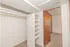 Spacious walk-in closet with built-in shelves and ample hanging space, offering practical storage solutions.