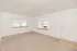 Bright, spacious living area with large windows and fresh carpet, offering a warm and inviting ambiance.