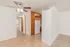 Inviting interior with ceiling fan, wooden cabinets, and tiled flooring leading to a cozy kitchen and hallway.