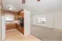 Bright, open-concept living area featuring a cozy carpeted space and a charming kitchen with warm wooden cabinets and modern appliances.
