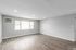 Spacious modern apartment with elegant hardwood floors and abundant natural light from large windows.