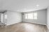 Bright and spacious living room in a modern apartment with sleek hardwood flooring, large window, and fresh neutral walls, perfect for personalization.