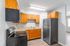 Modern kitchen with sleek stainless steel appliances, warm wooden cabinetry, and chic recessed lighting.