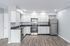 Contemporary kitchen with sleek white cabinetry, stainless steel appliances, and elegant hardwood floors.