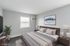 Modern, bright bedroom featuring sleek furniture, a cozy bed, and stylish decor with soothing wall art.