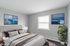 Elegantly staged bedroom with a plush bed, serene seaside artwork, and a cozy atmosphere, perfect for relaxation and comfort.