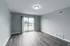 Bright living room with sleek hardwood flooring and large sliding glass doors opening to a picturesque balcony view.