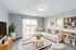 Bright and inviting living room with modern decor, featuring a cozy sectional, chic coffee table, and stylish bookshelves, complemented by natural light streaming through large glass doors.