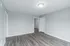 Bright apartment interior with modern gray flooring, clean white walls, and ample natural light.