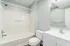 Bright, modern bathroom featuring a sleek bathtub, stylish vanity, and large mirror, perfect for a refreshing retreat.
