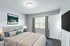 Inviting bedroom with plush bedding, elegant decor, and a large window offering natural light.