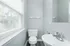 Bright and modern bathroom with sleek fixtures, a large window providing ample natural light, and a clean, contemporary design.