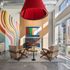 two chairs facing the floor to ceiling fireplaces with colorful art